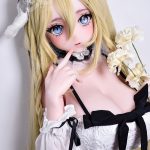 Anime-style doll with long blonde hair, blue eyes, wearing a white lace dress with black bow ribbons and a lace headpiece, holding cream-colored flowers.