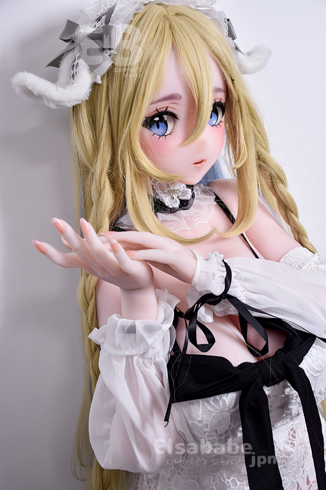 Life-size anime-style doll with long blonde hair and blue eyes, wearing a white lace cosplay outfit with black ribbons, posed with hands cupped in front