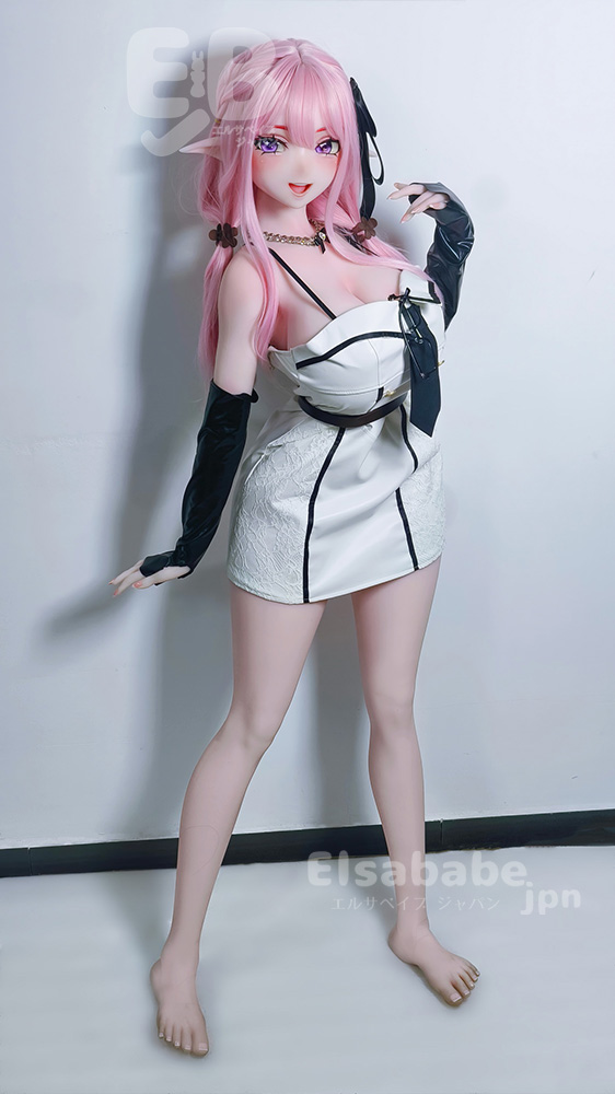 Life-size pink-haired anime-style doll in a white and black mini dress, standing against a white wall