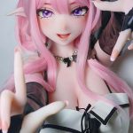 Close-up of a pink-haired anime-style doll with elf ears, wearing a black-and-white outfit and posing with outstretched hands toward the camera.
