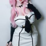 Cosplay-style mannequin/doll with pink hair, elf ears, glasses, and a white black-trim mini dress posing with a finger to her lips, wearing long black gloves.