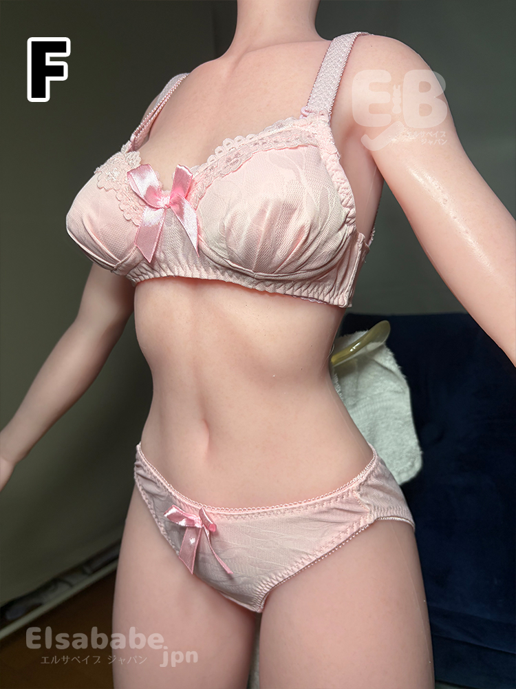Pink satin lingerie set on a mannequin: lace-trimmed bra with bows and matching panties with a small bow.